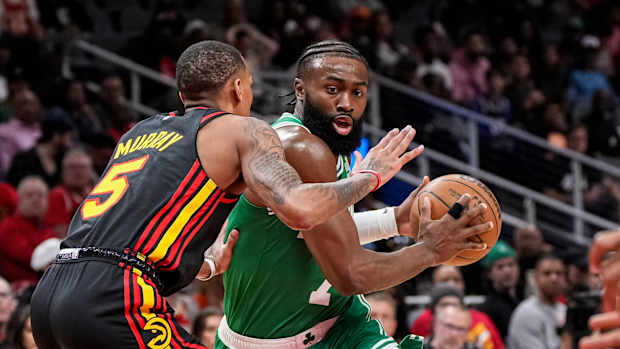Boston Celtics guard Jaylen Brown dribbles into Atlanta Hawks guard Dejounte Murray.